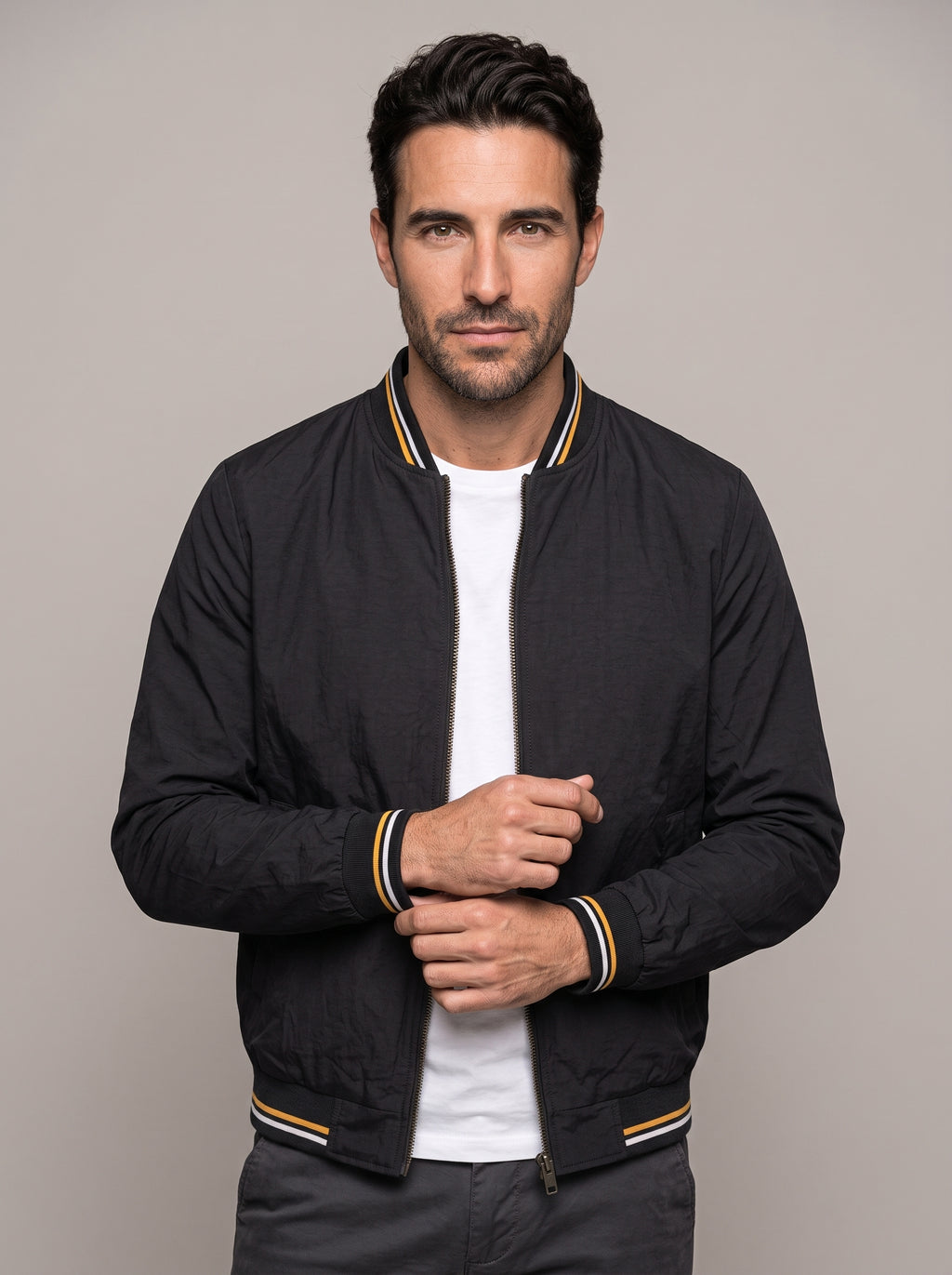 Hombre con chaqueta bomber clásica ÁNGEL IGNACIO en negro, vista en tres cuartos