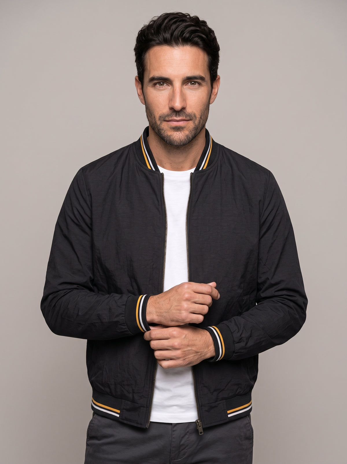 Hombre con chaqueta bomber clásica ÁNGEL IGNACIO en negro, vista en tres cuartos