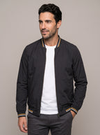 Chaqueta bomber ÁNGEL IGNACIO negra abierta sobre camiseta blanca, vista de frente