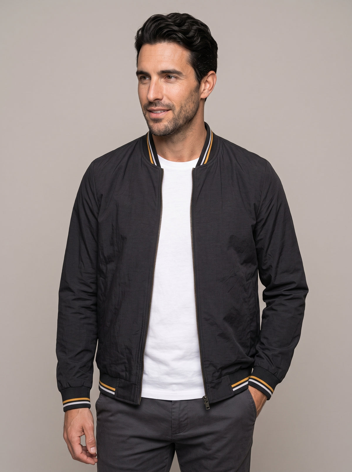 Chaqueta bomber ÁNGEL IGNACIO negra abierta sobre camiseta blanca, vista de frente