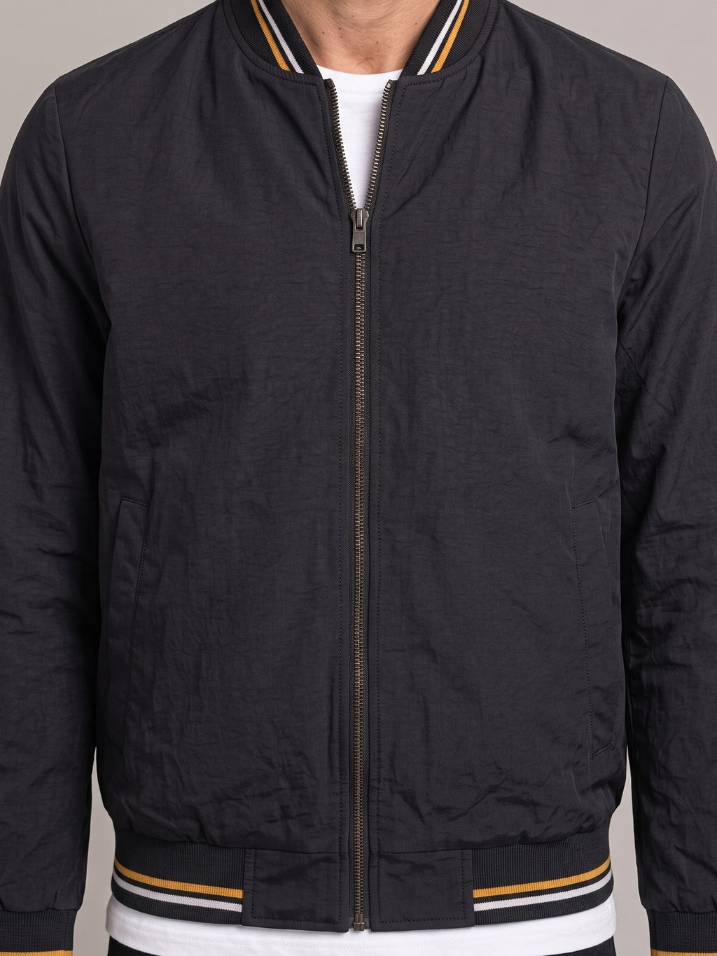 Detalle del cuello de punto y la cremallera de la chaqueta bomber ÁNGEL IGNACIO